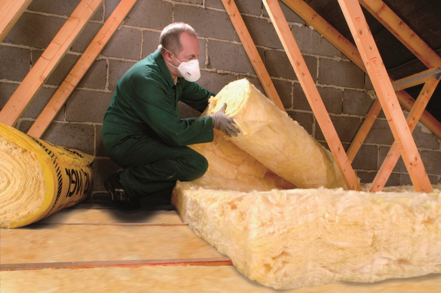 man insulating a loft
